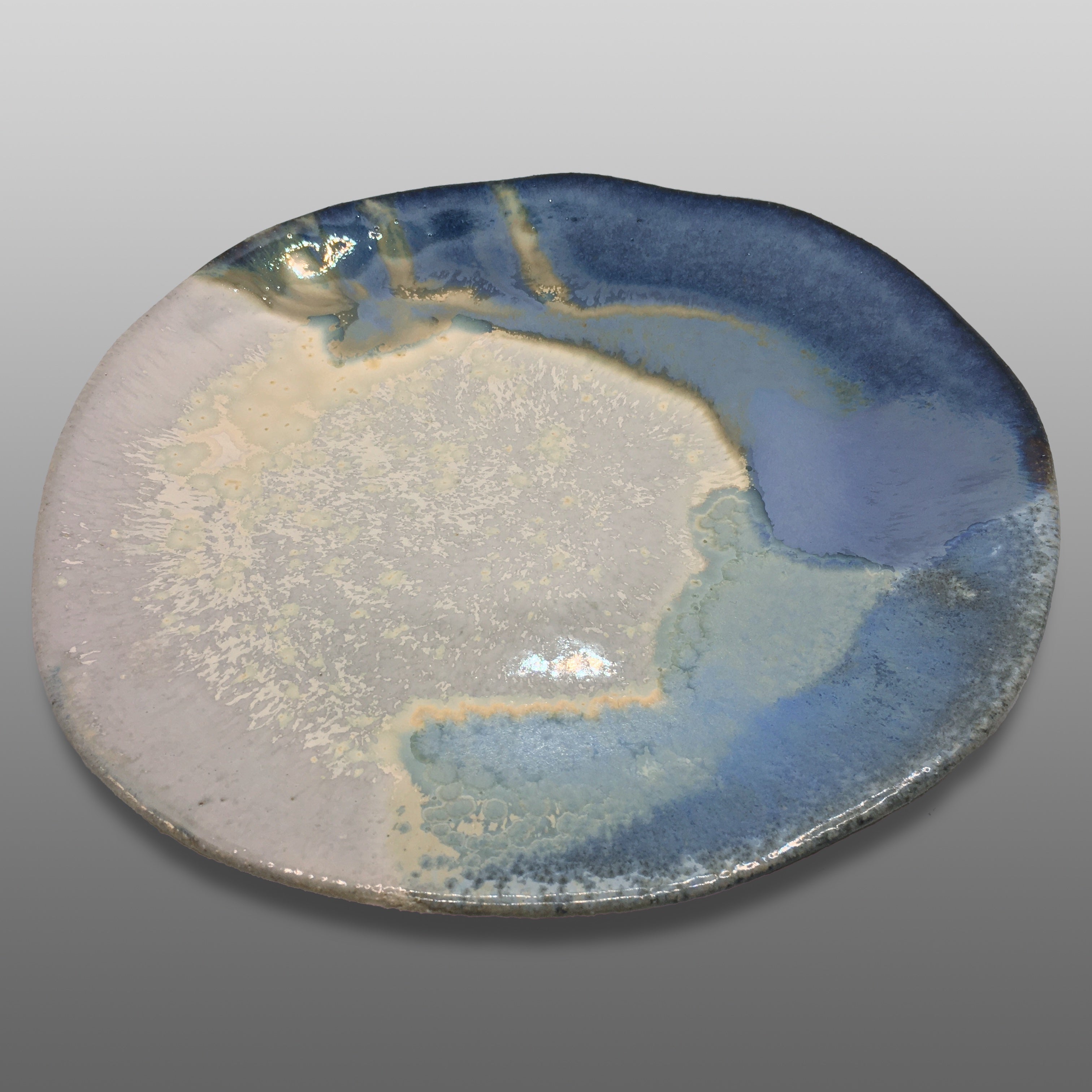Assiette irrégulière grès écrue émaillée bleu blanc